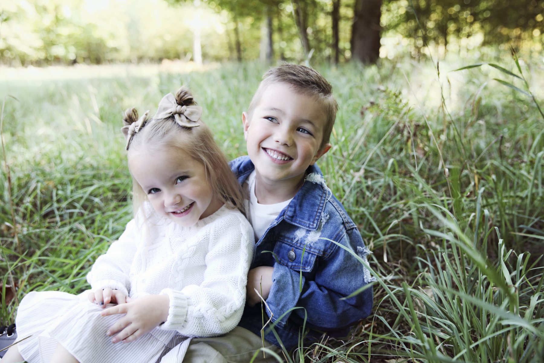 Brother and sister laughing in tall grass
